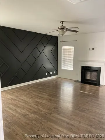a view of a livingroom with wooden floor and a fireplace