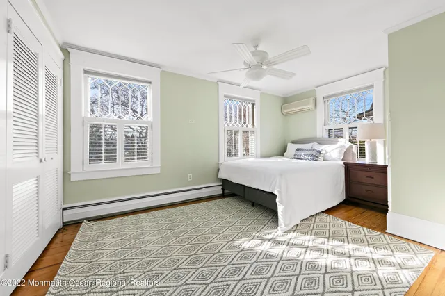 a bedroom with a bed lamp closet and three windows