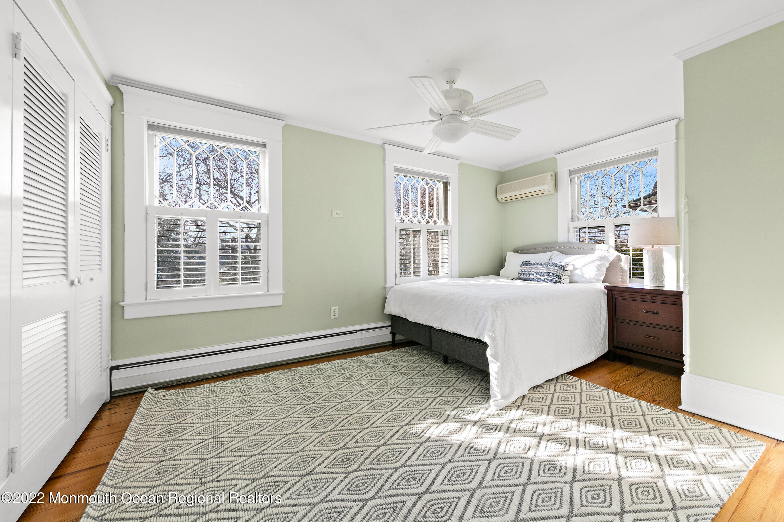 116 Tuttle Avenue Spring Lake, NJ 07762 - Photo 30 of 45 a bedroom with a bed lamp closet and three windows
