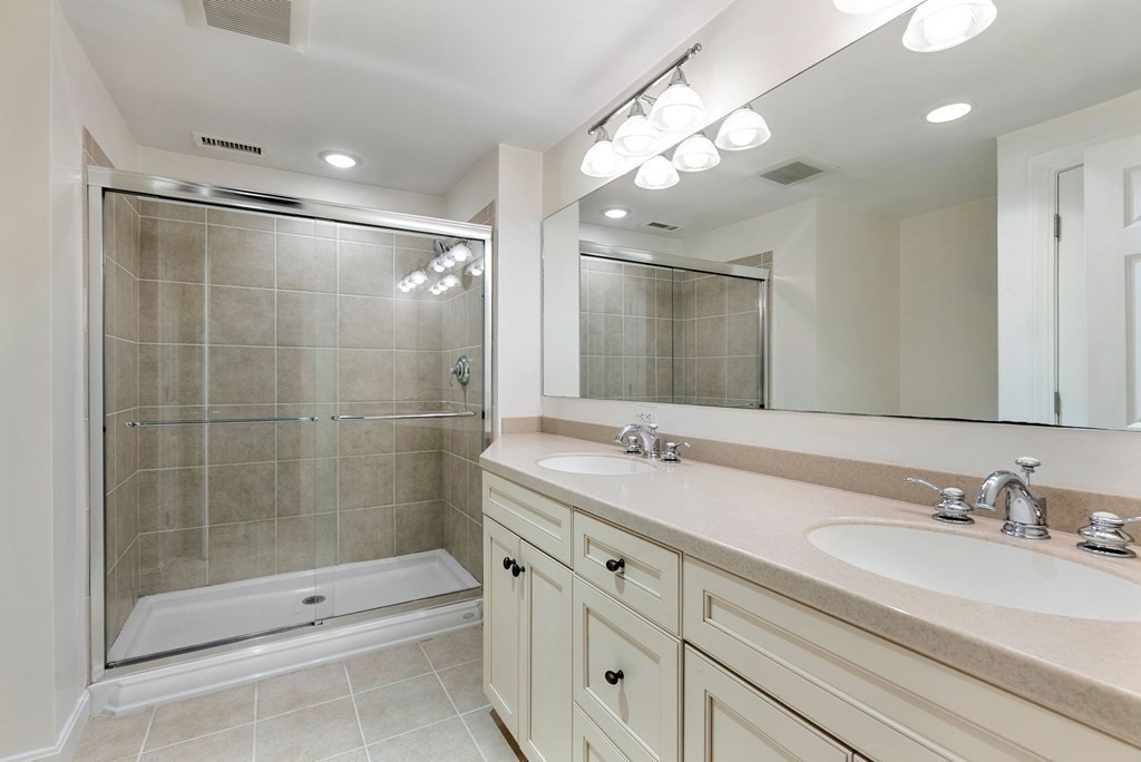 79 Jericho Road, Unit 79 Weston, MA 02493 - Photo 11 of 16 a bathroom with a shower sink vanity granite and mirror