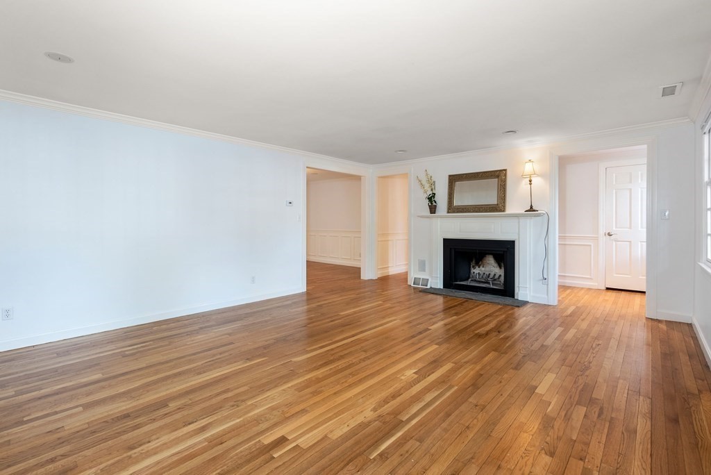 79 Jericho Road, Unit 79 Weston, MA 02493 - Photo 2 of 16 a view of empty room with wooden floor and fireplace
