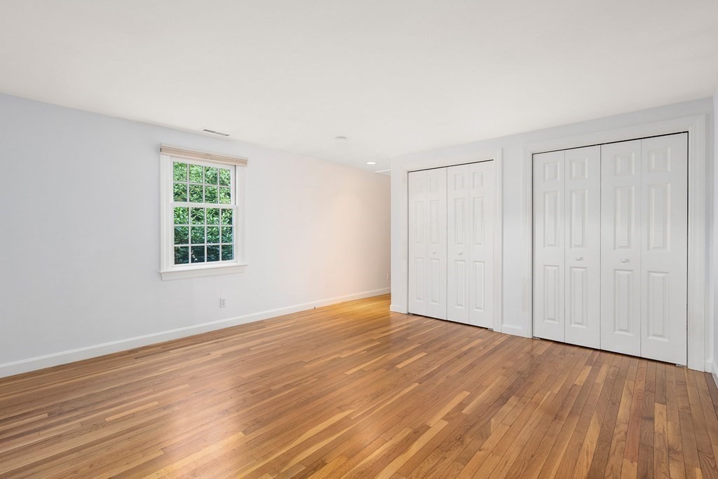 79 Jericho Road, Unit 79 Weston, MA 02493 - Photo 9 of 16 an empty room with wooden floor and windows