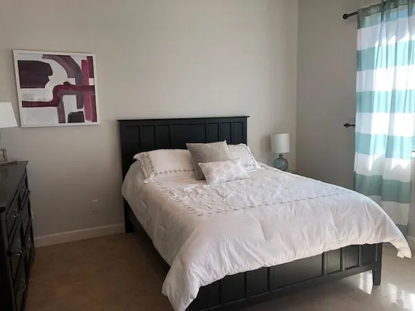 a large bed sitting in a bedroom next to a window