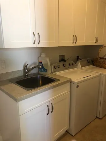 a view of a sink and dishwasher with washer dryer