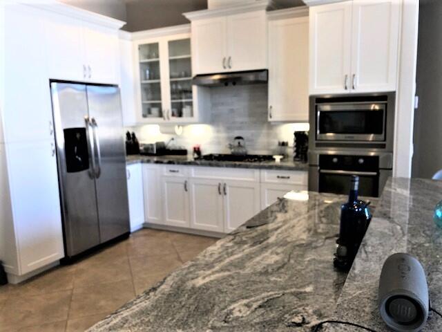 74130 Pele Place Palm Desert, CA 92211 - Photo 4 of 19 a kitchen with granite countertop a sink stainless steel appliances and cabinets