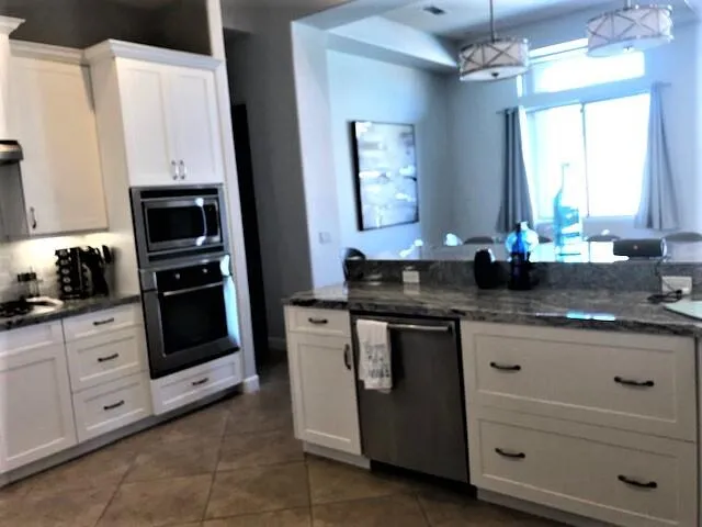 a kitchen with granite countertop white cabinets and white appliances