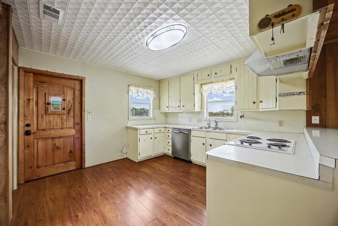 17019 Rocky Ridge Road Austin, TX 78734 - Photo 13 of 37 a kitchen with cabinets wooden floor and a window