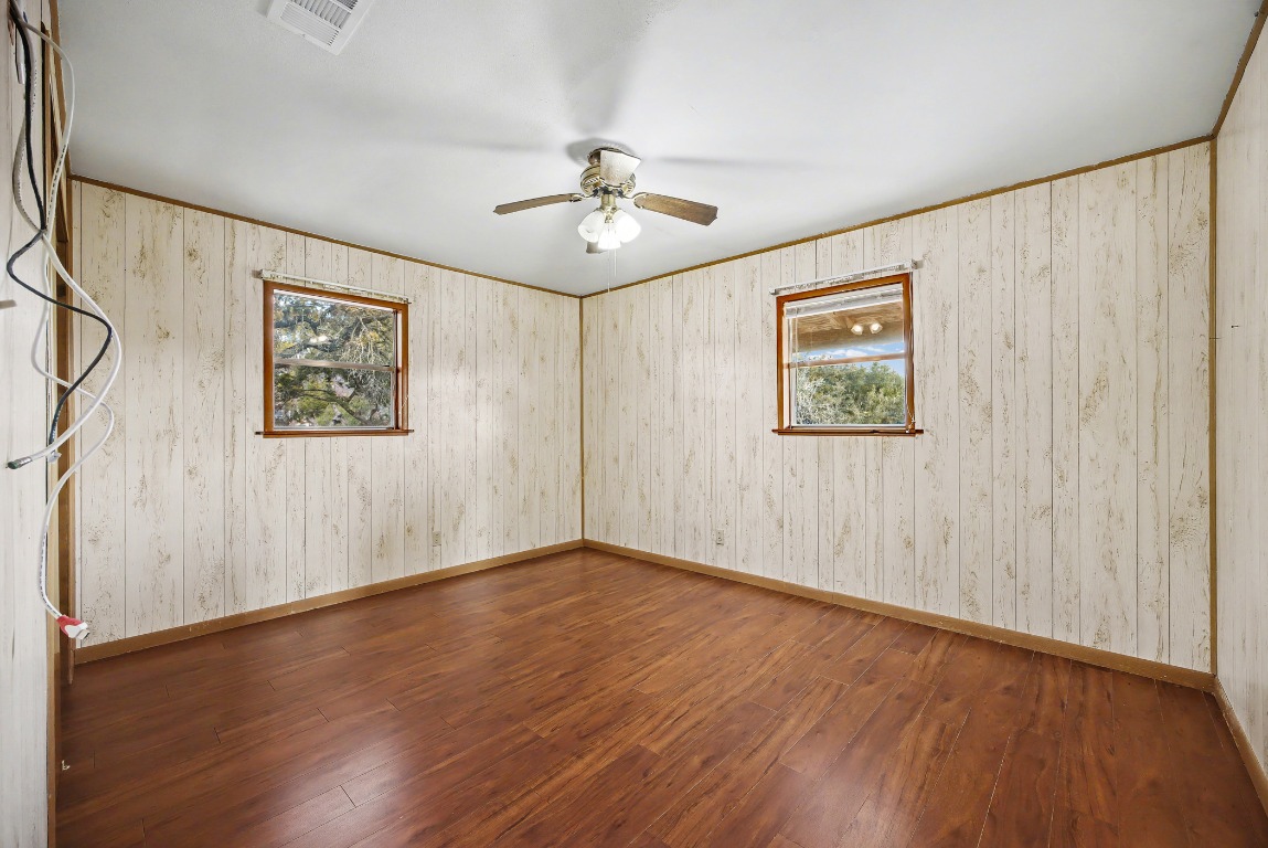 17019 Rocky Ridge Road Austin, TX 78734 - Photo 16 of 37 a view of an empty room with wooden floor and a ceiling fan