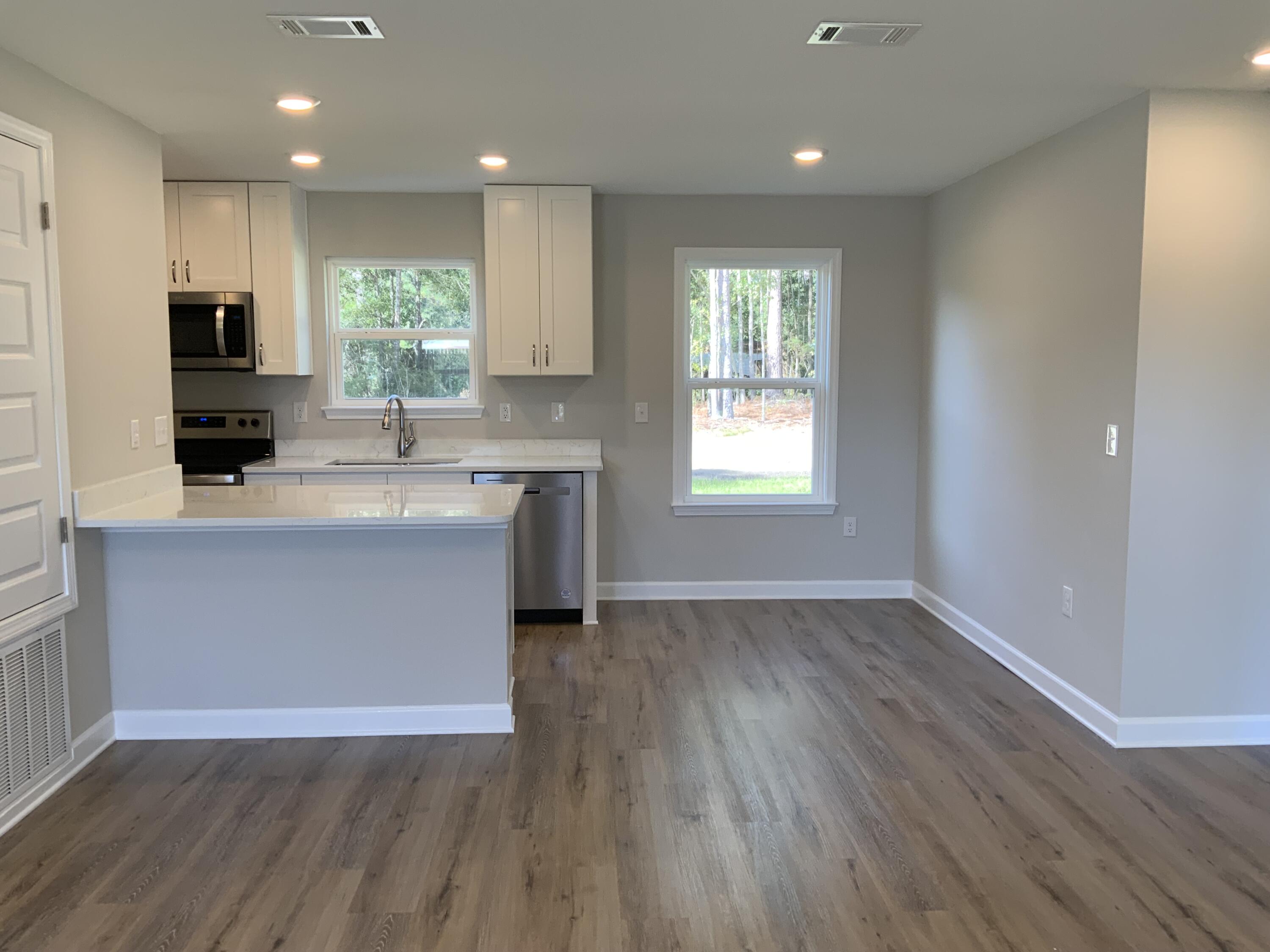 200 South Norwood Road DeFuniak Springs, FL 32435 - Photo 3 of 7 a kitchen with kitchen island granite countertop a sink a counter space and stainless steel appliances