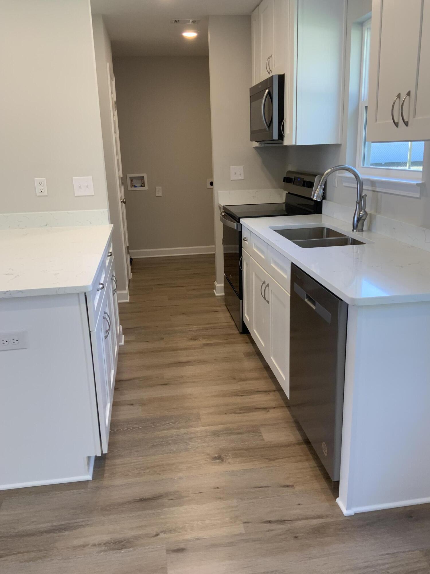 200 South Norwood Road DeFuniak Springs, FL 32435 - Photo 4 of 7 a kitchen with a sink and a wooden floor