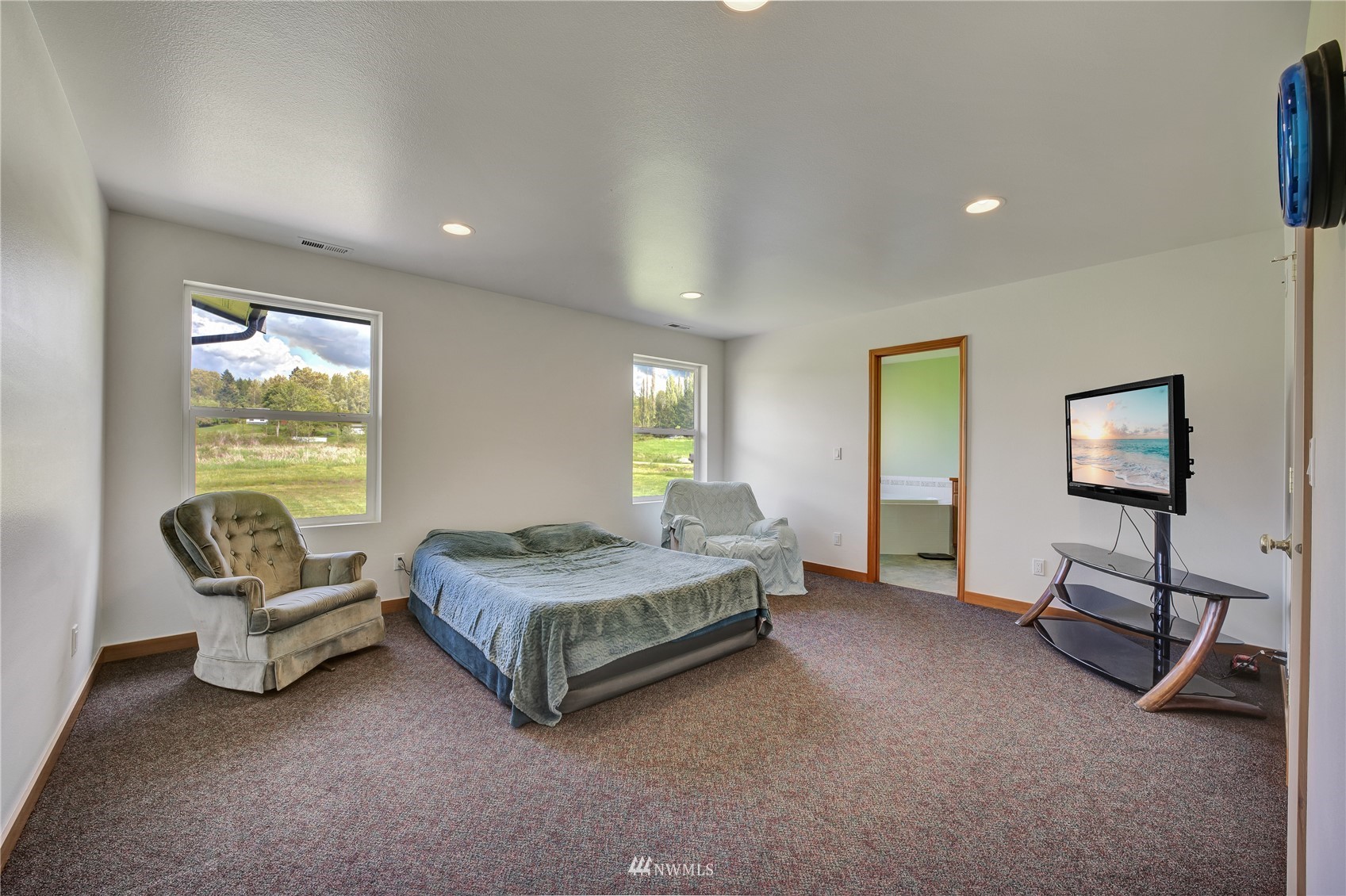 12112 Roosevelt Road Snohomish, WA 98290 - Photo 28 of 36 a spacious bedroom with a bed and a chandelier