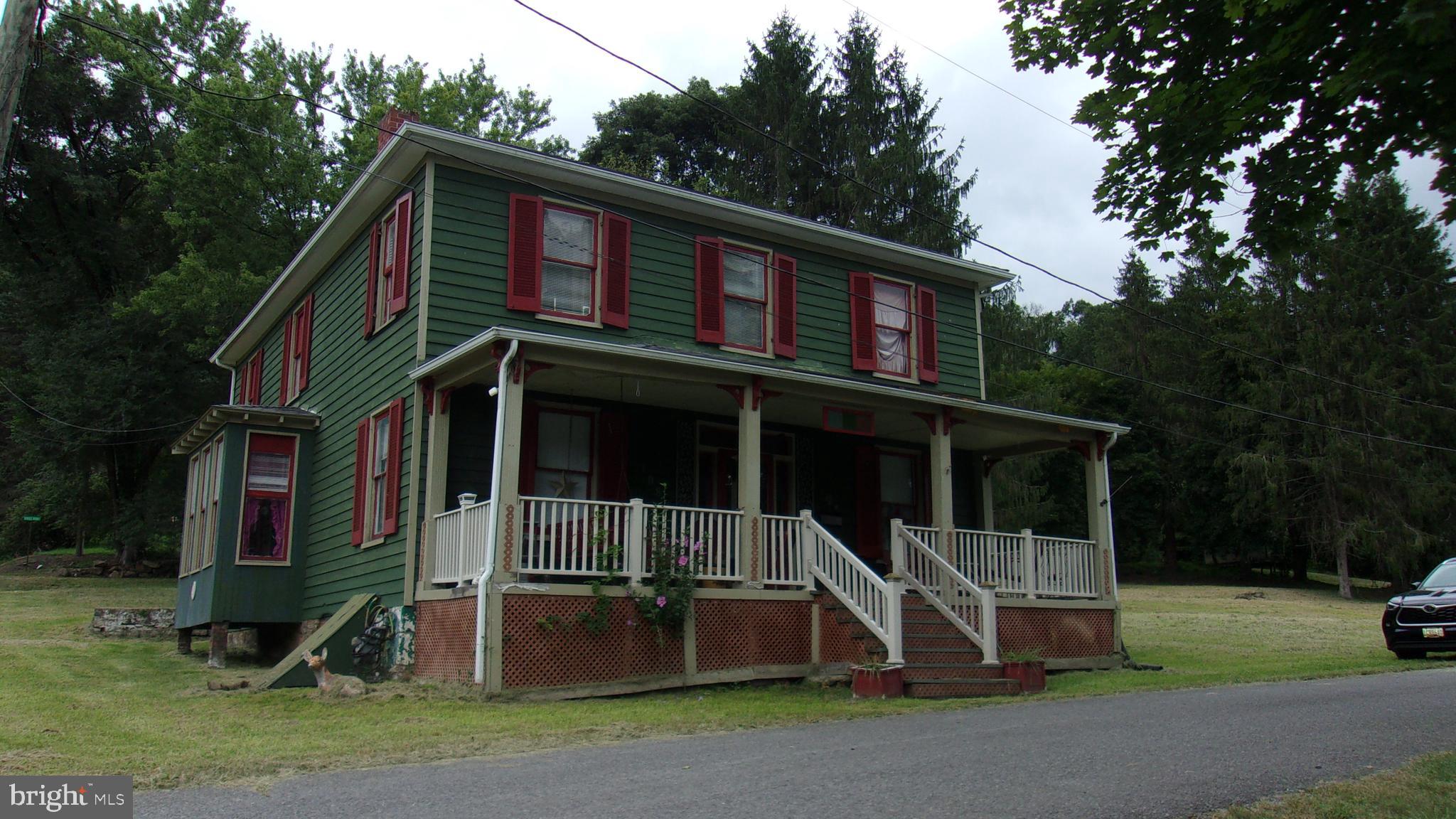 a front view of a house with a garden and trees