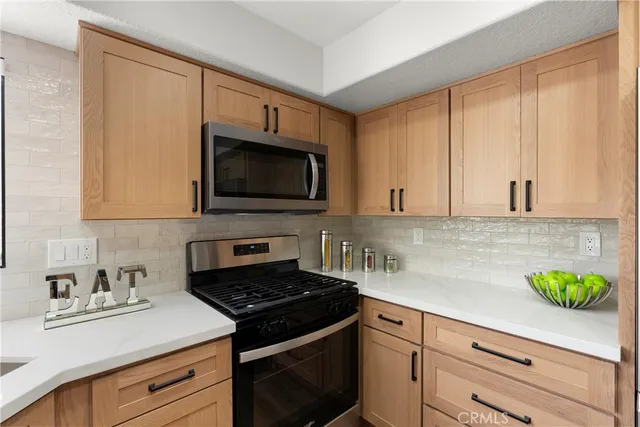 a kitchen with stainless steel appliances a sink dishwasher stove microwave and cabinets