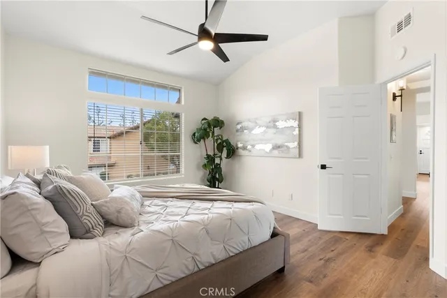 a bedroom with a large bed chandelier and a window
