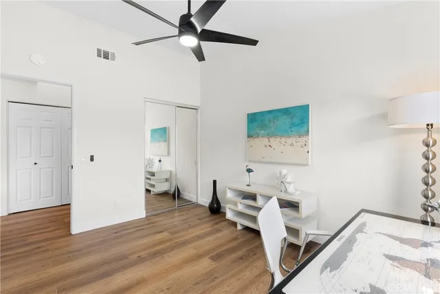 a view of a bedroom with wooden floor and ceiling fan