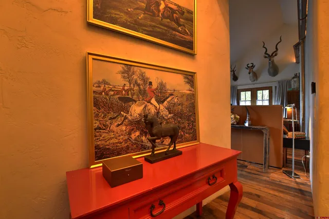 a dining room with furniture a chandelier and wooden floor