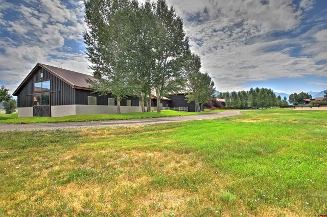 a front view of a house with a yard and trees