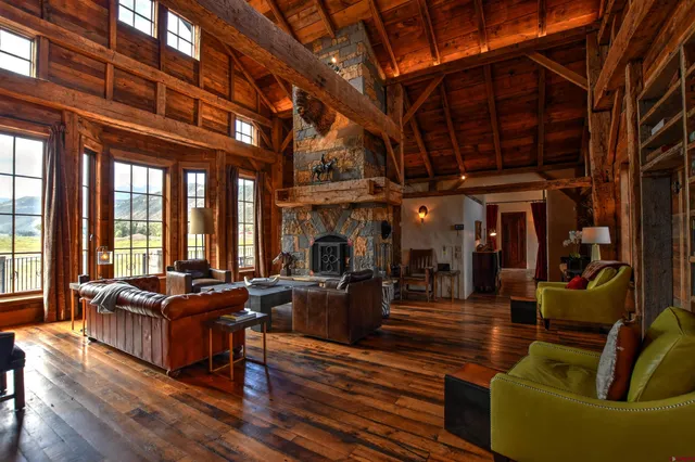 a living room with furniture a fireplace and a large window