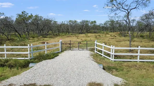 a view of a yard with wooden fence