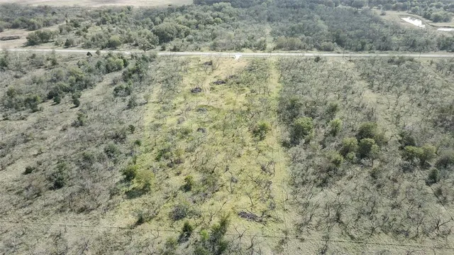 a view of a field with trees in the background