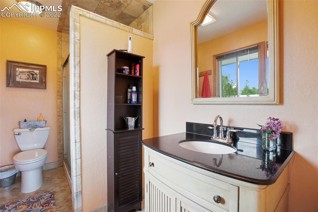 12 Ridge Drive Divide, CO 80814 - Photo 23 of 49 a bathroom with a granite countertop sink and a toilet