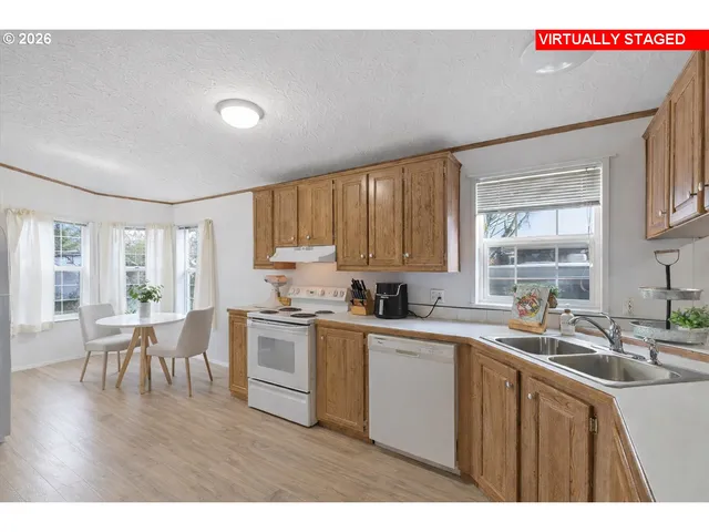 a kitchen with a sink wooden cabinets and white appliances