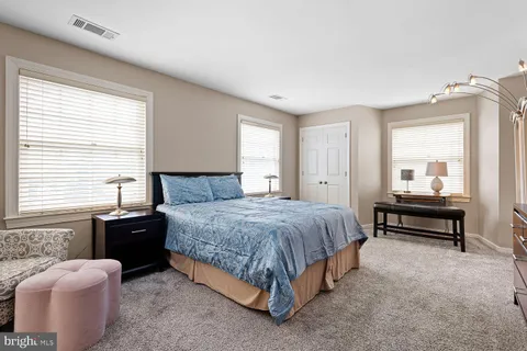 a spacious bedroom with a bed and a dresser