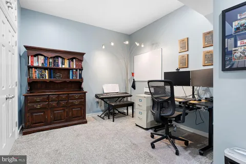 a view of a workspace with furniture and a bookshelf