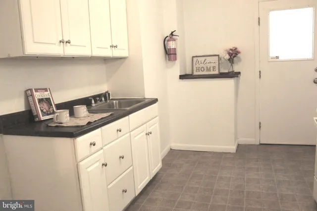 a kitchen with granite countertop white cabinets and sink