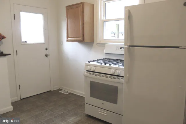 a kitchen with cabinets appliances and a window