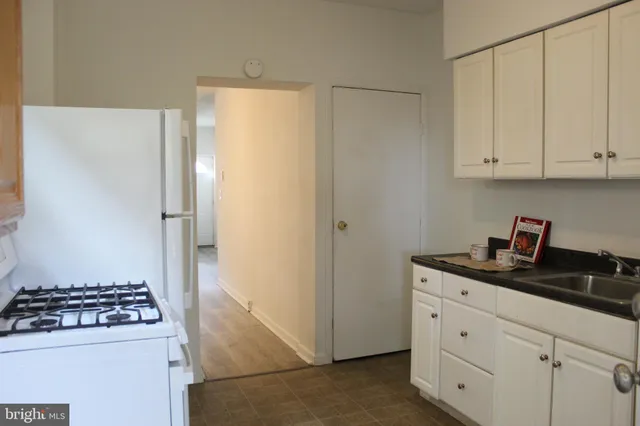 a kitchen with white cabinets and appliances