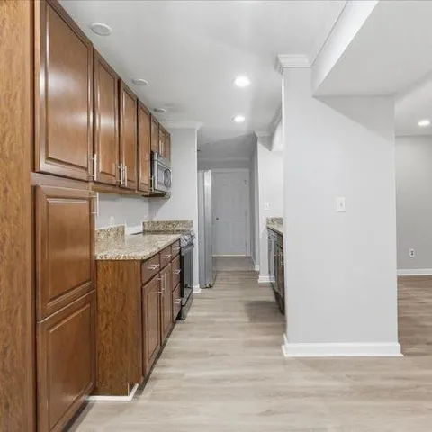 a kitchen with granite countertop cabinets stainless steel appliances and a counter space