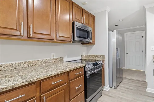 a kitchen with granite countertop stainless steel appliances a refrigerator and a counter top