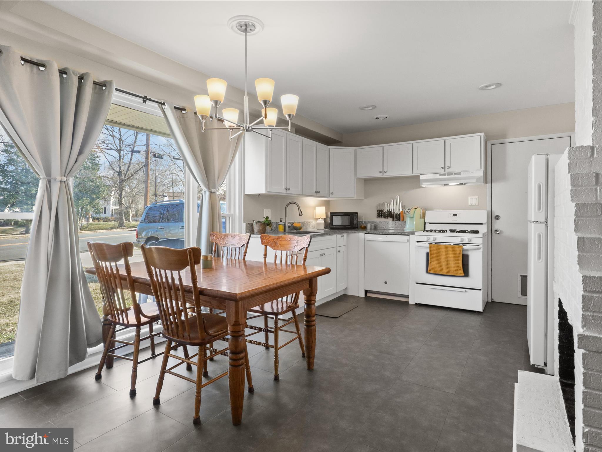 5908 Hanover Avenue Springfield, VA 22150 - Photo 14 of 32 a kitchen with stainless steel appliances granite countertop a stove a sink a refrigerator a dining table and chairs with wooden floor