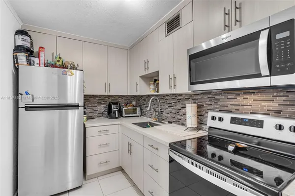 a kitchen with cabinets stainless steel appliances and a counter space