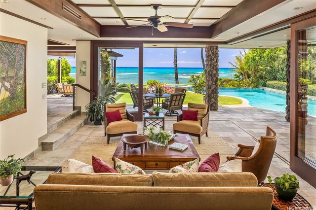 a living room with patio furniture and a floor to ceiling window
