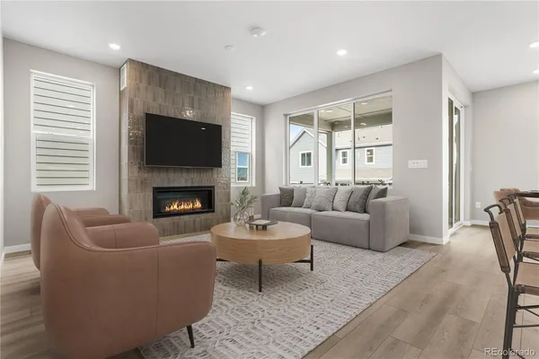 a living room with furniture a flat screen tv and a fireplace