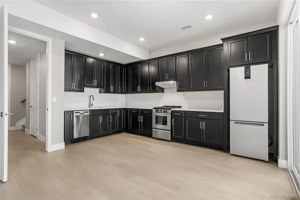 a kitchen with stainless steel appliances a refrigerator and a sink