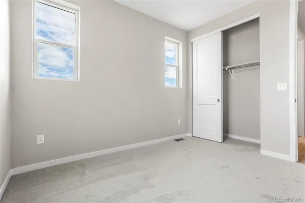 an empty room with windows and closet
