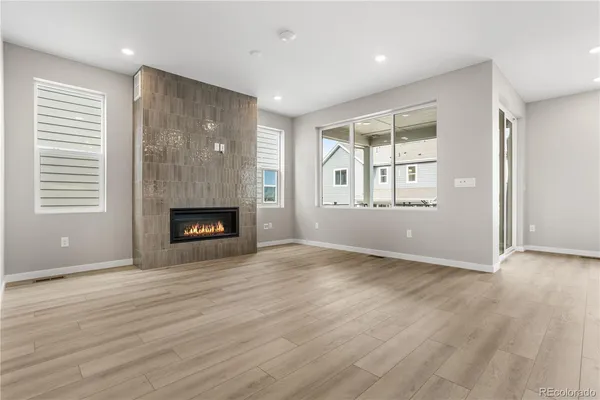an empty room with windows and fireplace