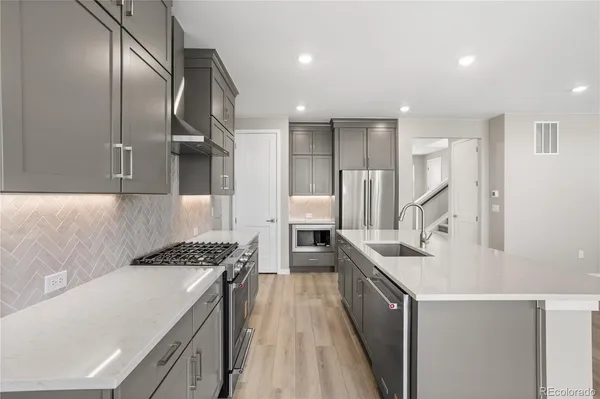 a kitchen with stainless steel appliances granite countertop a sink stove and refrigerator
