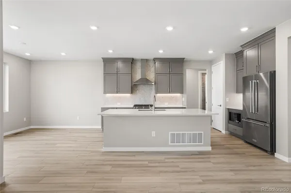 a kitchen with stainless steel appliances granite countertop a sink a refrigerator and a stove