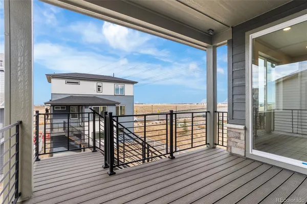 a view of a balcony with wooden floor and iron stairs