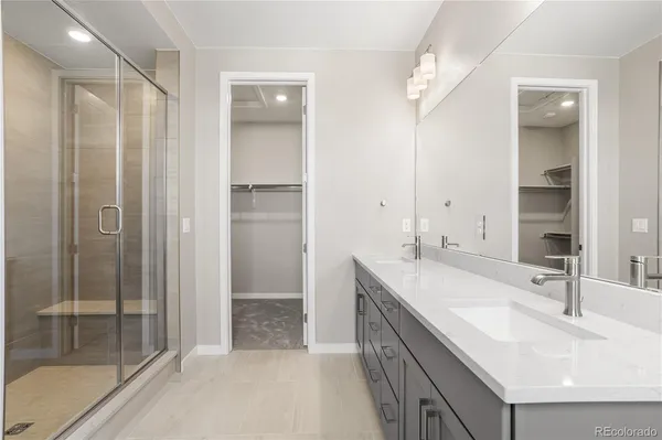 a bathroom with a double vanity sink mirror and shower
