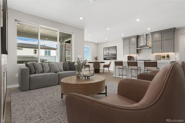 a living room with furniture kitchen view and a large window