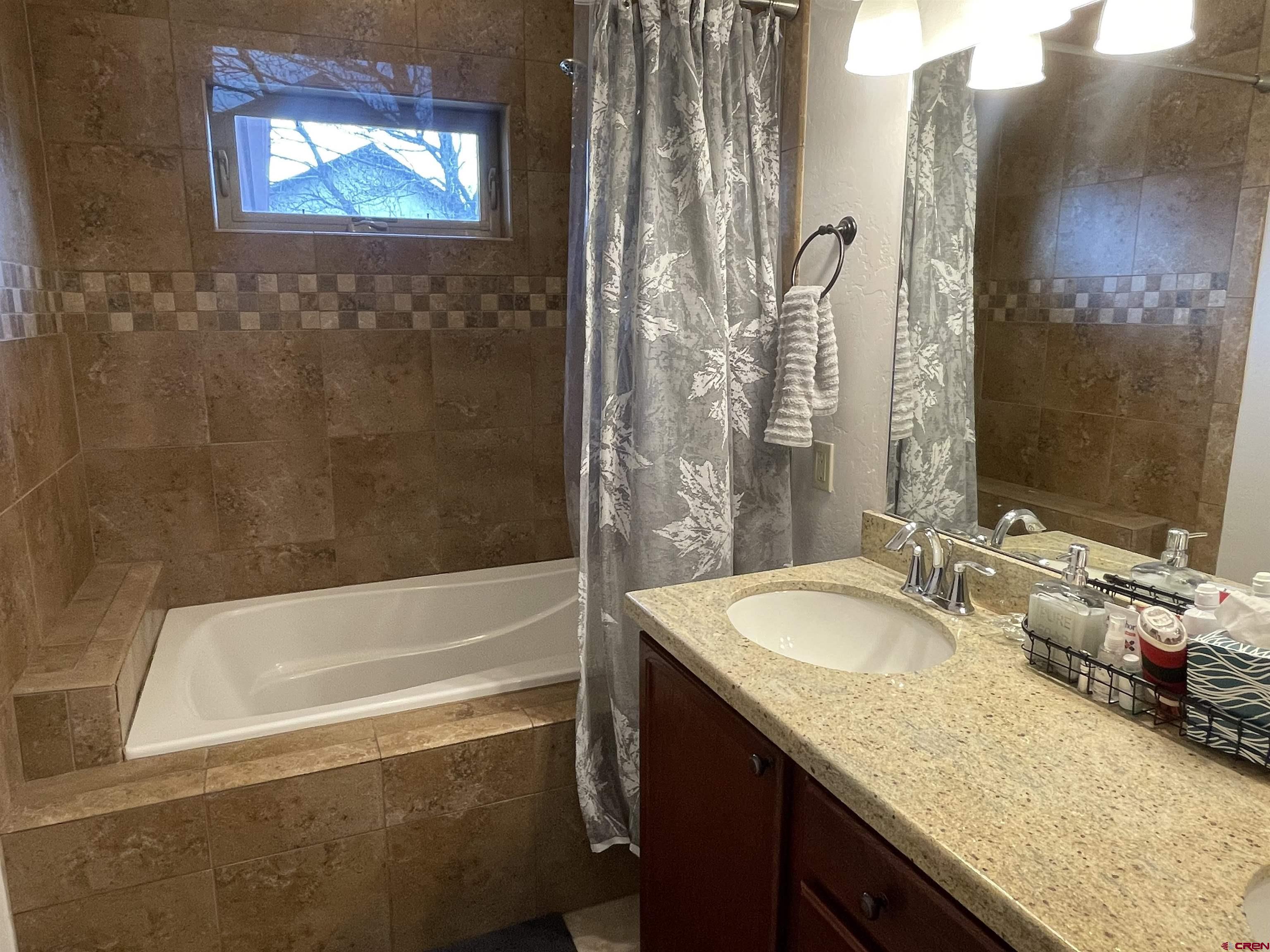 2271 Par Drive Cortez, CO 81321 - Photo 15 of 36 a bathroom with a granite countertop tub sink and mirror
