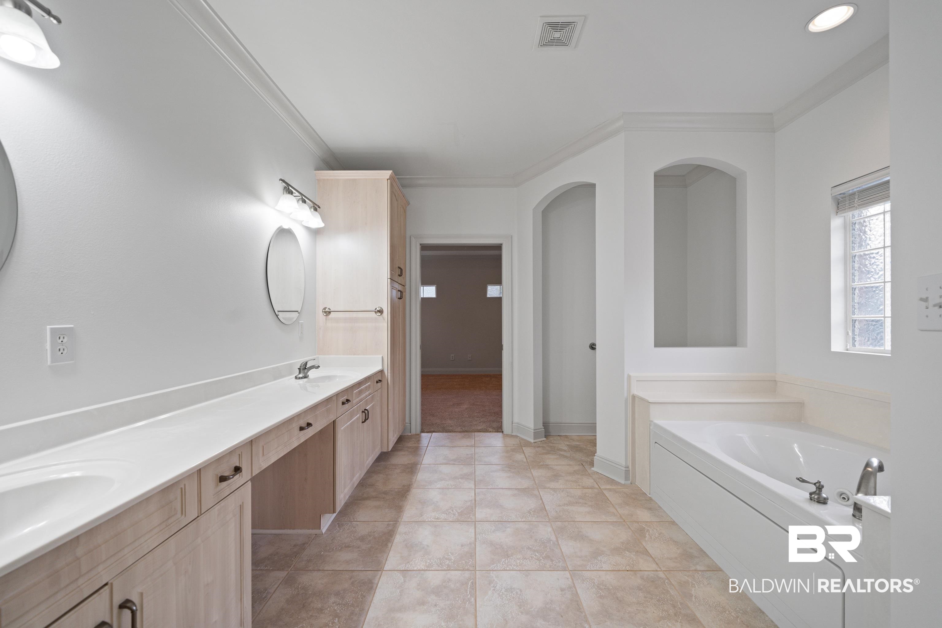 404 Savannah Lane Foley, AL 36535 - Photo 26 of 29 Full bath with visible vents, a bath, tile patterned floors, double vanity, and crown molding