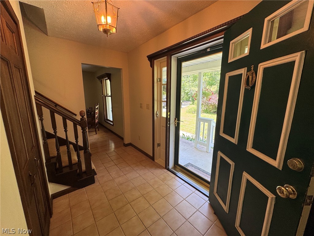8201 Orchard Road Painesville, OH 44077 - Photo 7 of 45 Inviting entryway featuring tile flooring and a decorative overhead light fixture