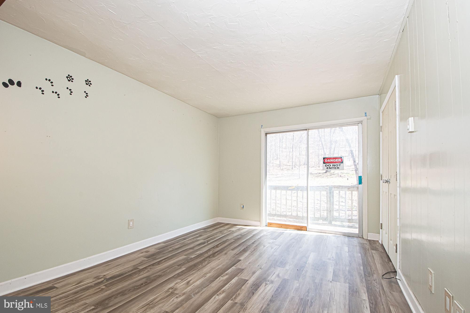 4792 Howellsville Road Front Royal, VA 22630 - Photo 37 of 41 a view of an empty room with wooden floor and a window