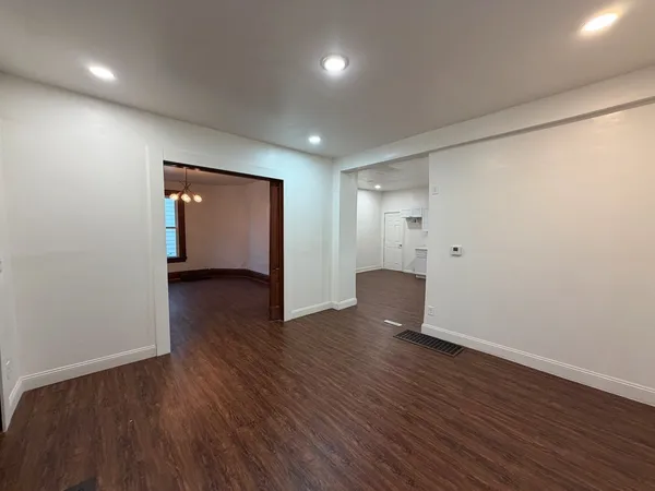 a view of an empty room with wooden floor